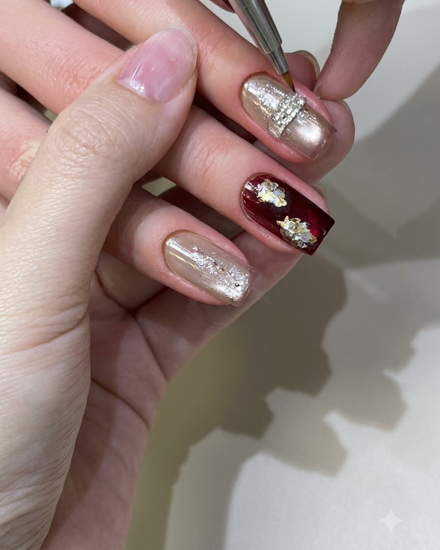 A detail brush working on textured gel details over a cured nail under studio lighting.