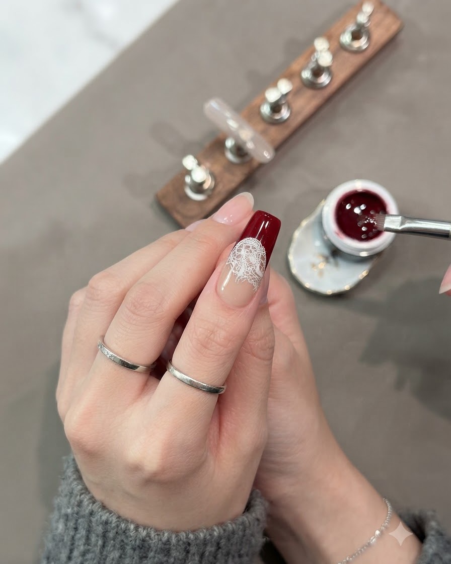 A brush completely filling in the lower section of the nail tip with dark red cat-eye gel.