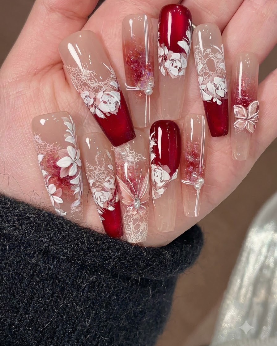 A fine nail art brush drawing thin accent lines on top of white floral nail decorations.