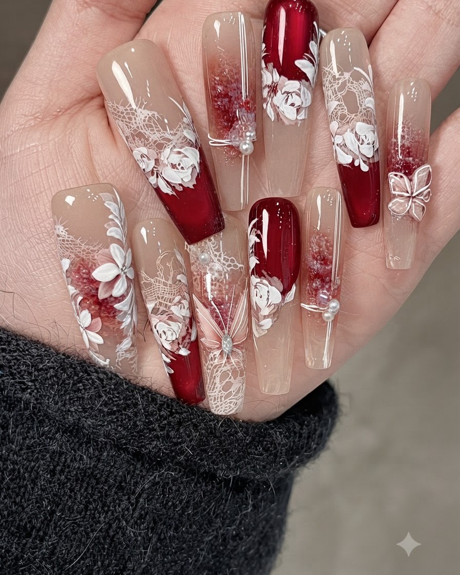 A close-up of a decorated nail featuring fine metallic string lines, pearls, and crushed stone accents.