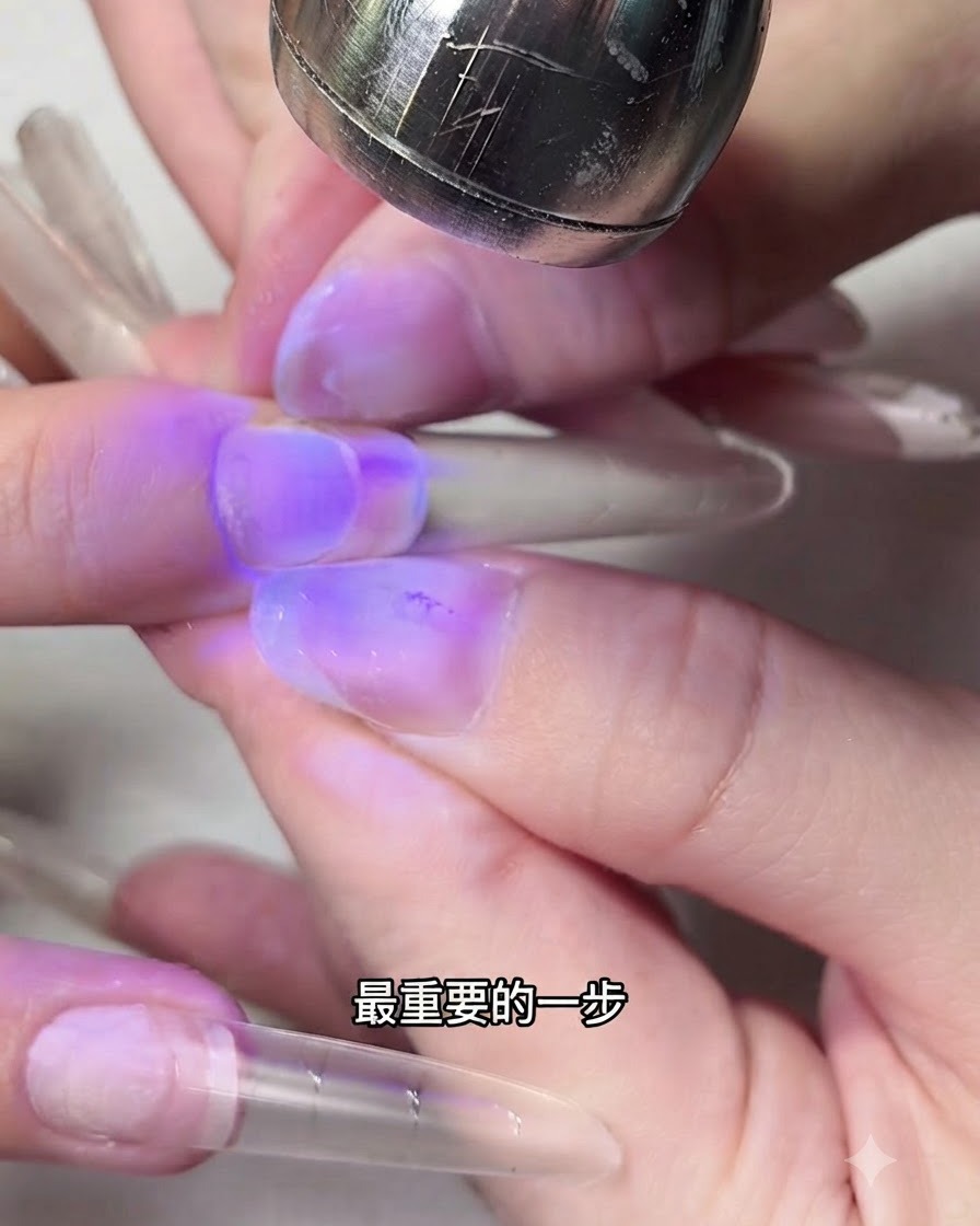 Fingers pinching the sides of a nail extension under purple UV light.