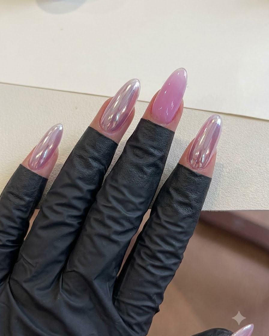A hand with finished purple gel nails resting under lighting during the curing stage.