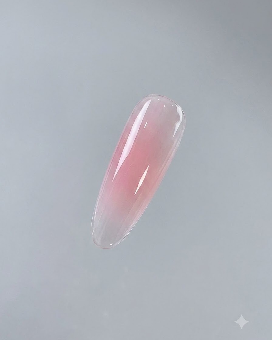 A finished single nail showing a glossy, cured pink base coat against a neutral background.