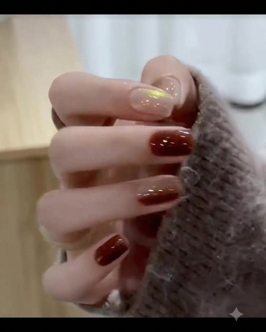 A brush depositing a rich caramel brown gel onto the tip portion of the fingernail.