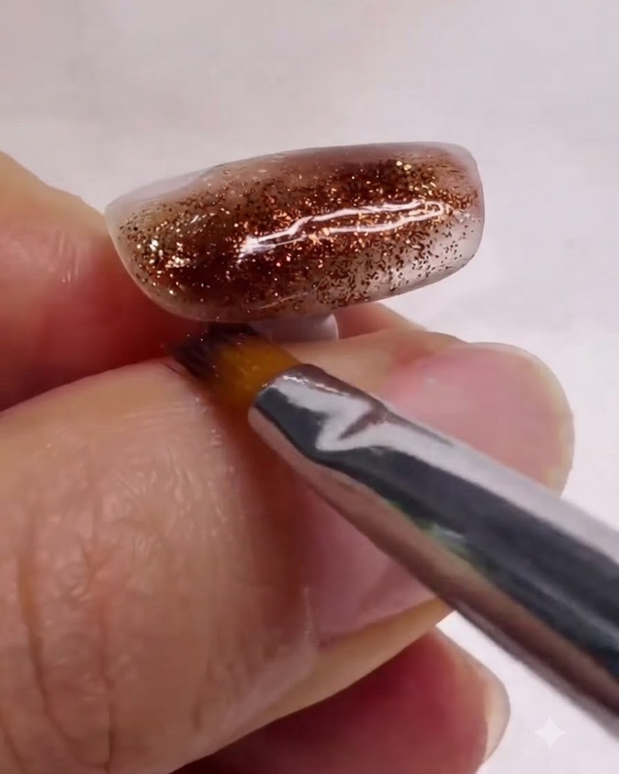 A clean nail art brush gently smoothing and blending white and brown marble layers on a textured nail.
