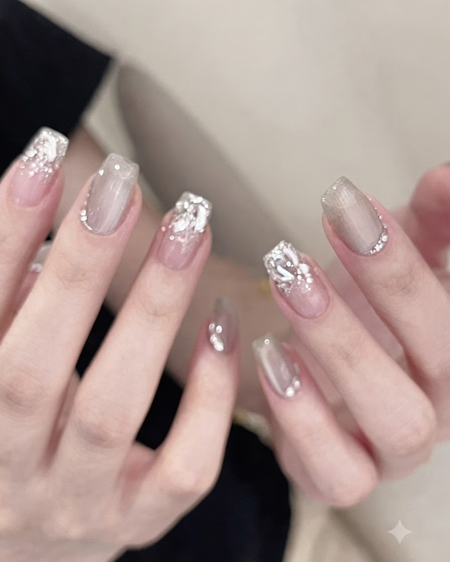 A hand placed inside a professional UV nail lamp, curing the rhinestones and adhesive on the nails.