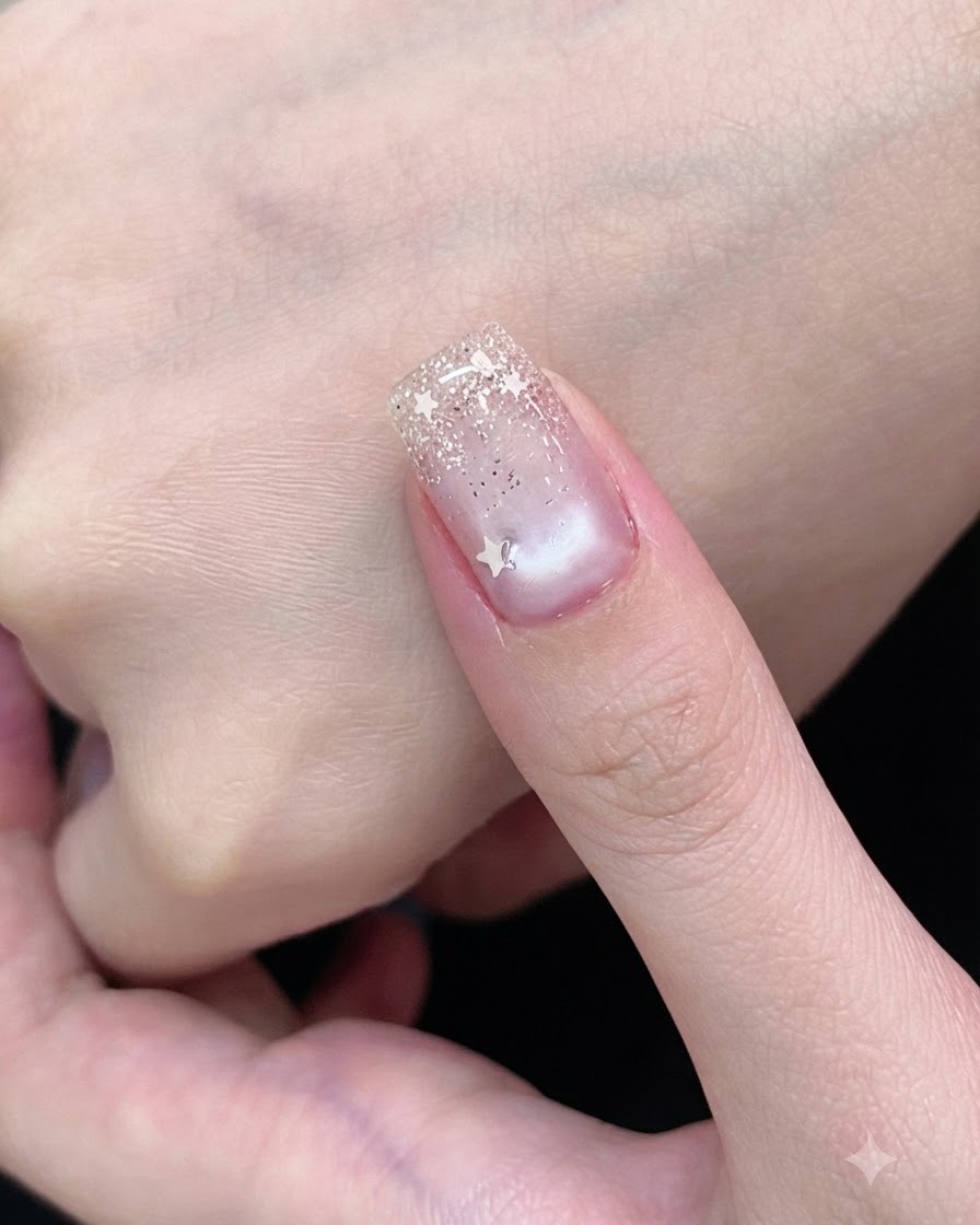 A gel brush coating a fingernail with a sheer white cat-eye polish.