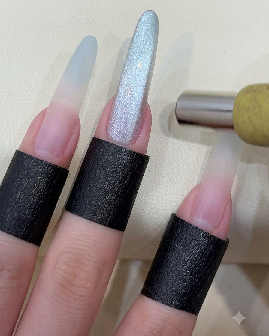 A cylindrical magnet being held over a long manicured nail to shape cat eye magnetic particles.