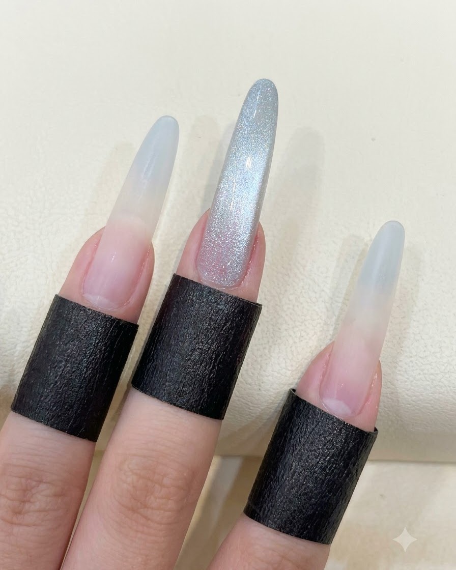 A hand showing long almond nails with the completed glass bead cat eye reflection.