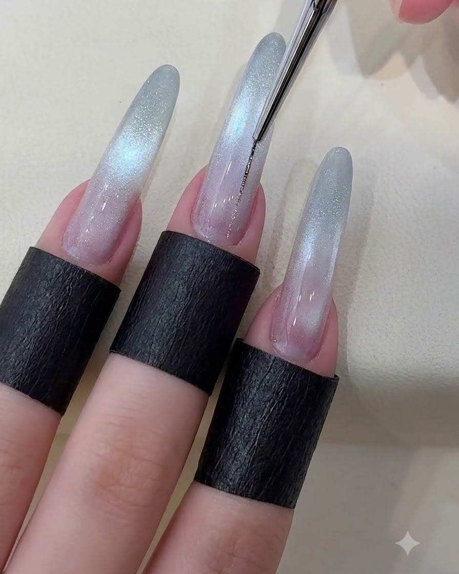 A fine liner brush drawing a thin metallic silver line down the center of a starry cat eye nail.