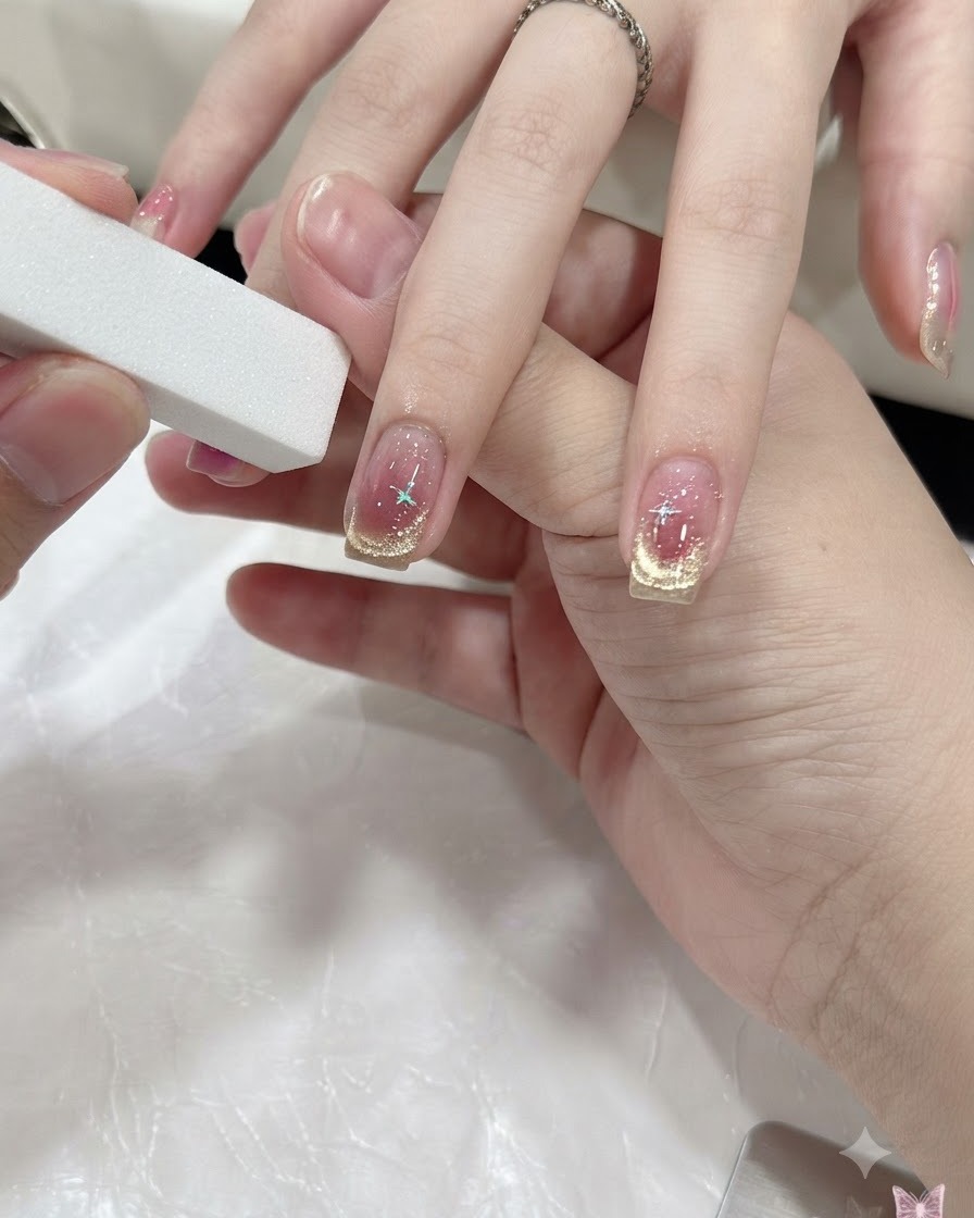 A hand curing nails under a compact mini UV/LED lamp.