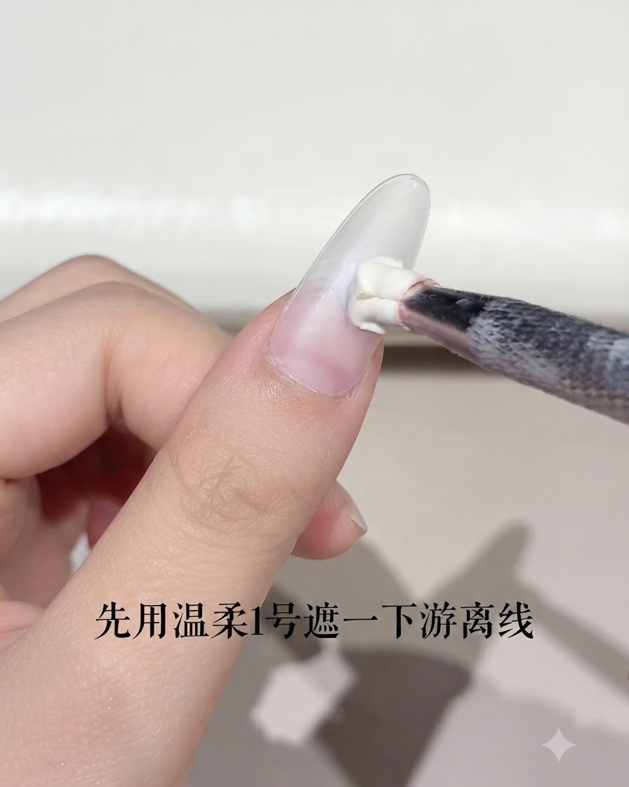 A nail brush applying a small amount of white gel to the free edge of an almond-shaped nail.