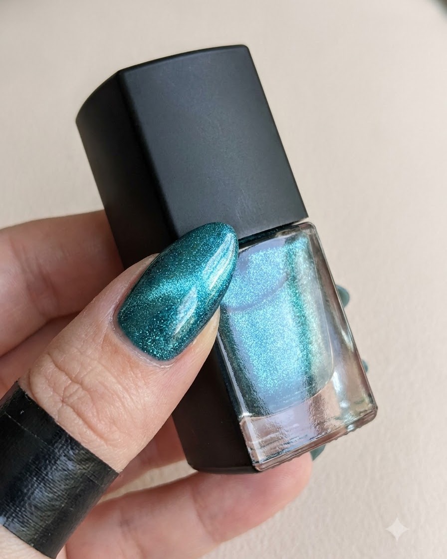 A bottle of top coat next to a cured nail ready for magic powder.