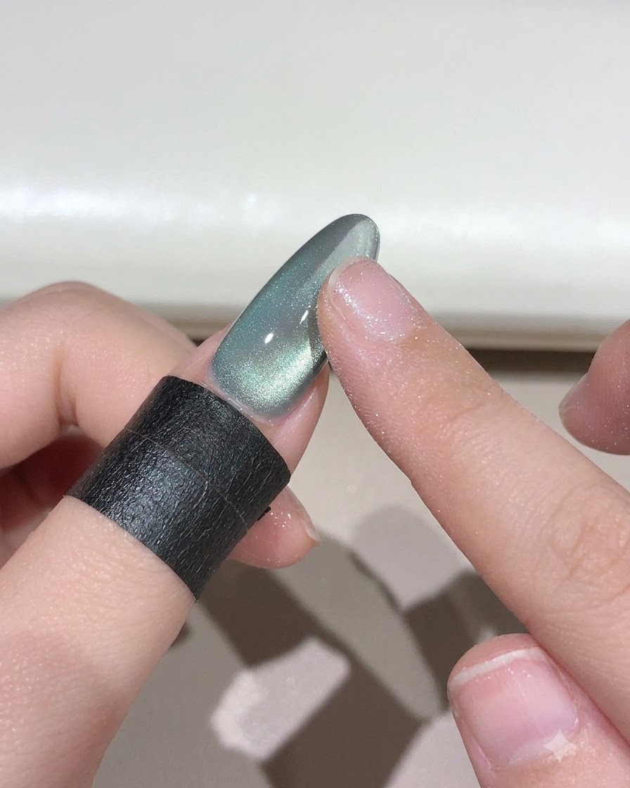 A finger rubbing sky-to-realm magic powder onto a nail to create a gradient effect.