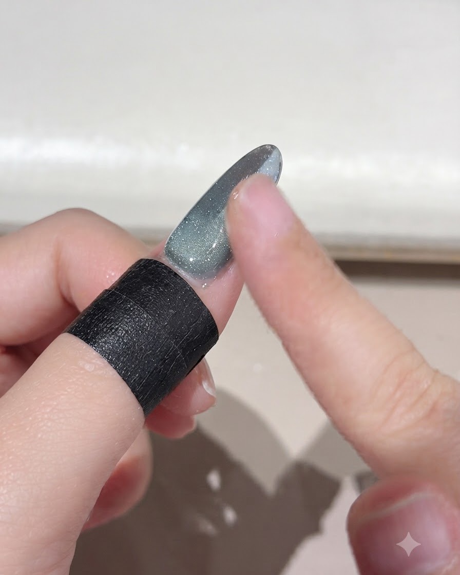 A finger brushing away excess loose magic powder from a gradient nail surface.