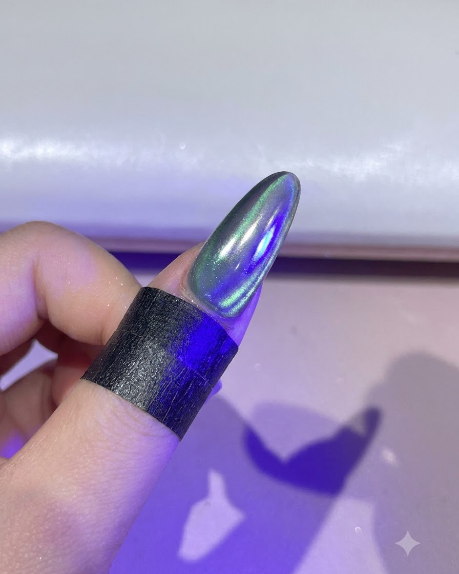 A fingernail illuminated under a purple UV/LED curing lamp.