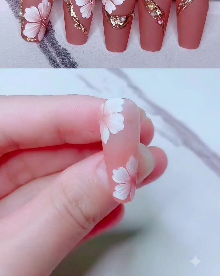 A fine liner brush drawing delicate gold gel lines around a floral nail art design.