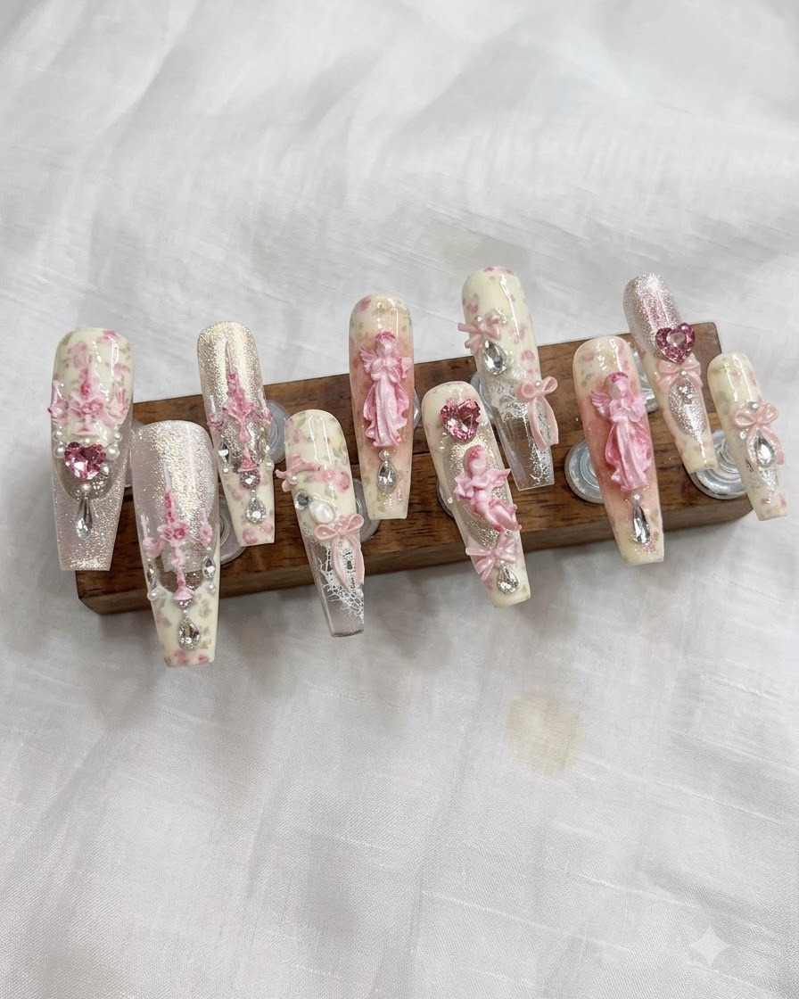 A nail brush spreading a light bean paste white gel color evenly onto the nail.