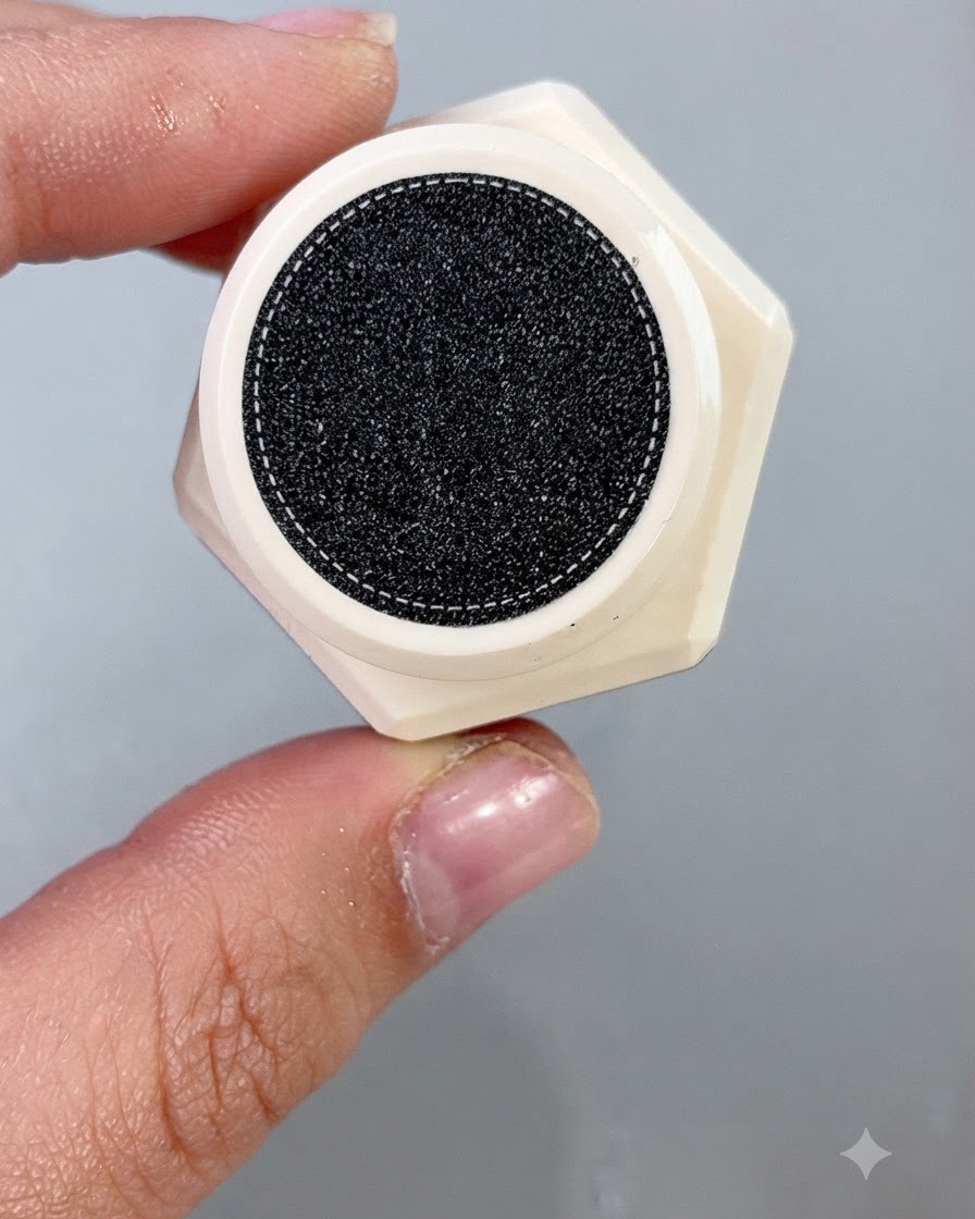 A nail polish brush applying a shimmering cantaloupe cat eye gel uniformly onto a false nail tip.