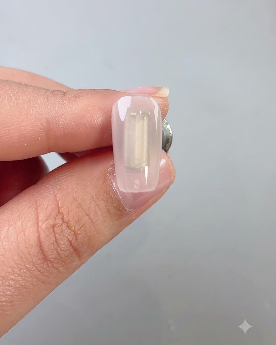 A nail brush applying a coat of dark green wilderness cat eye gel evenly over a nail.