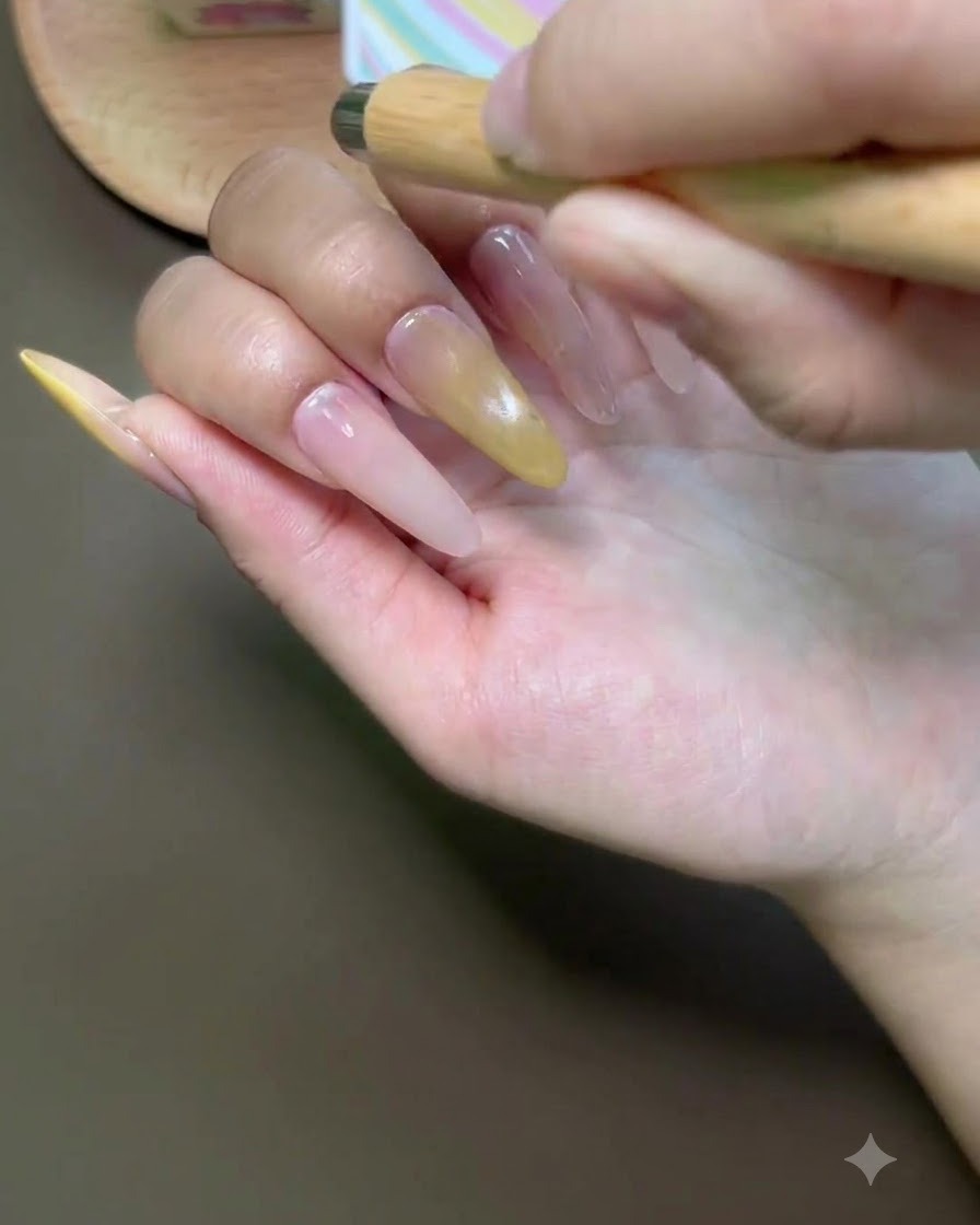A brush applying cat-eye gel polish onto the index fingernail.