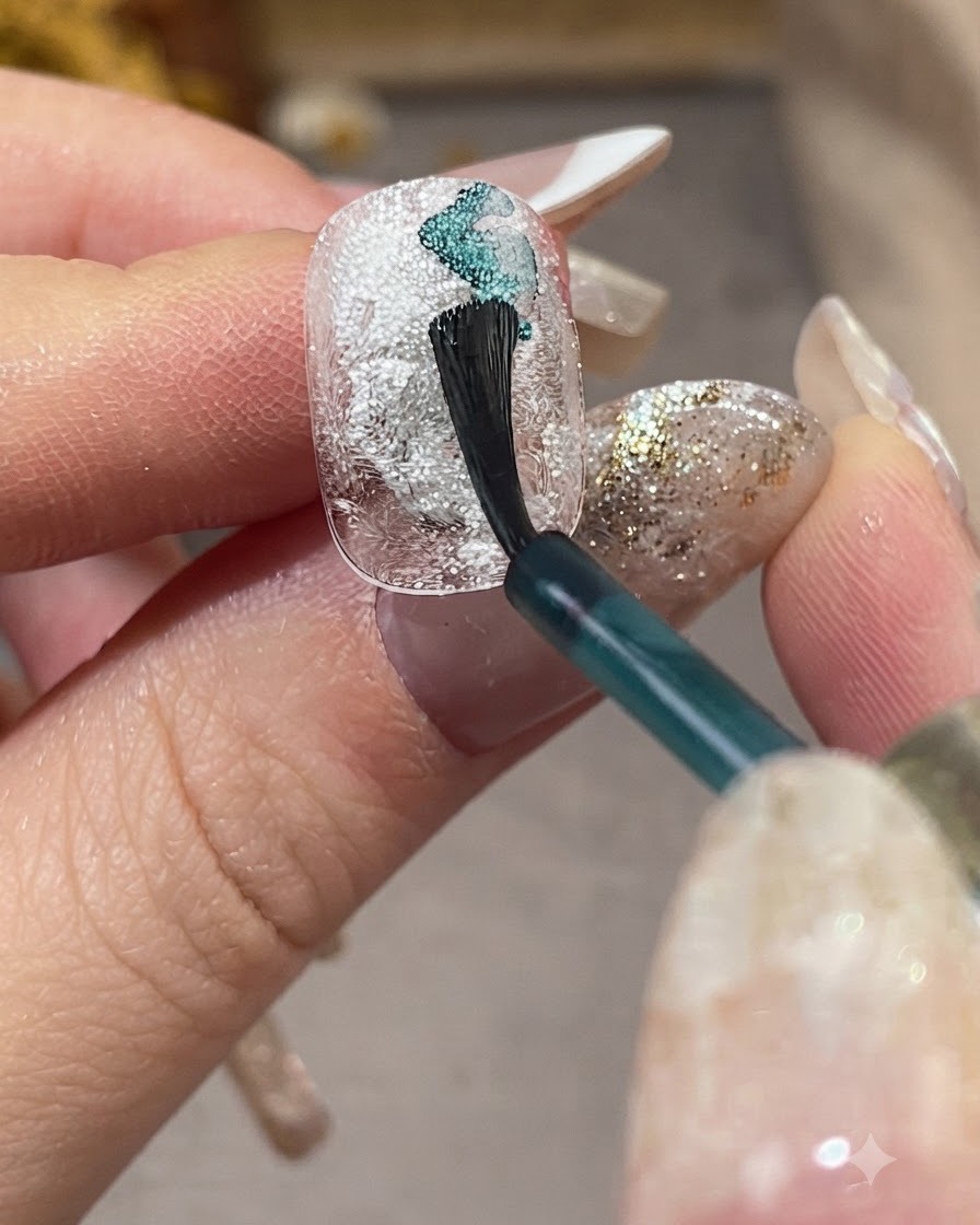 A nail brush applying light blue smudging liquid diagonally across a textured white nail.
