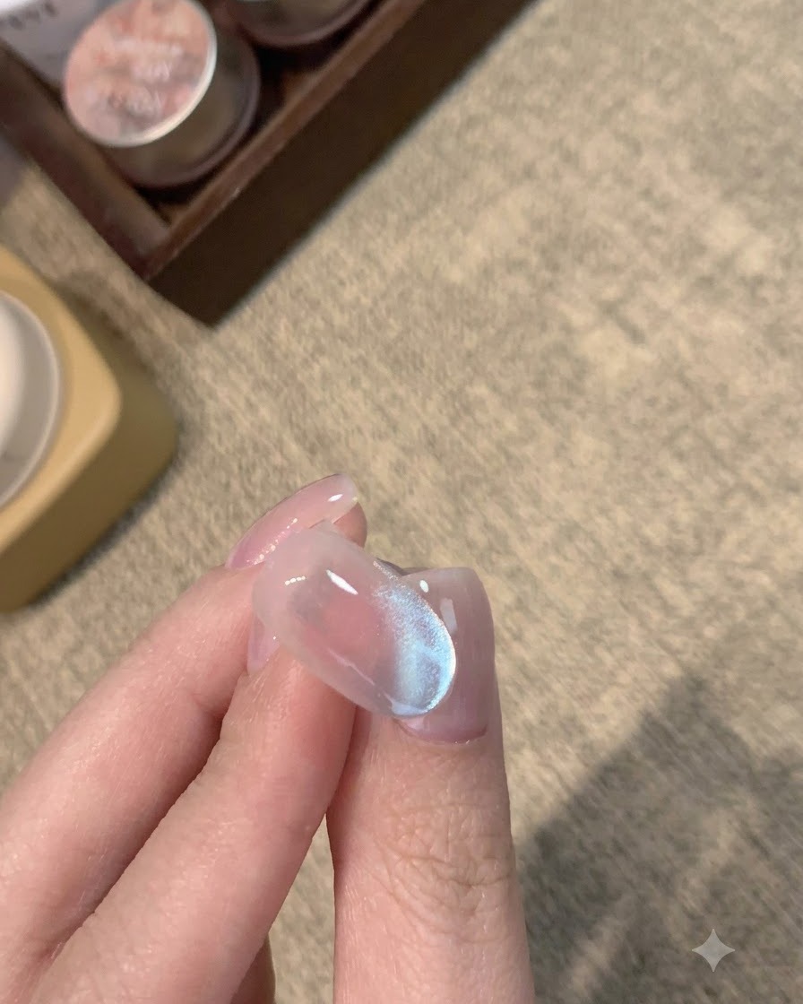 A completed matte nail with a frosty blue cat-eye shimmer underneath.