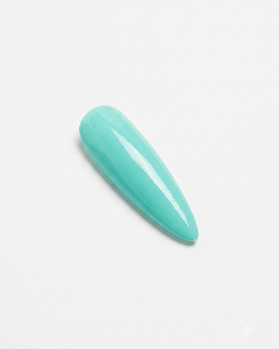 A finished mint green nail resting under a compact pink UV/LED curing lamp.