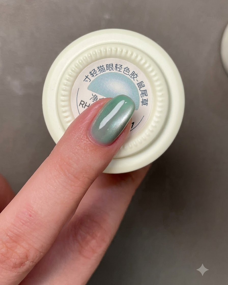 A brush applying a grayish-blue gel polish onto a fingernail.