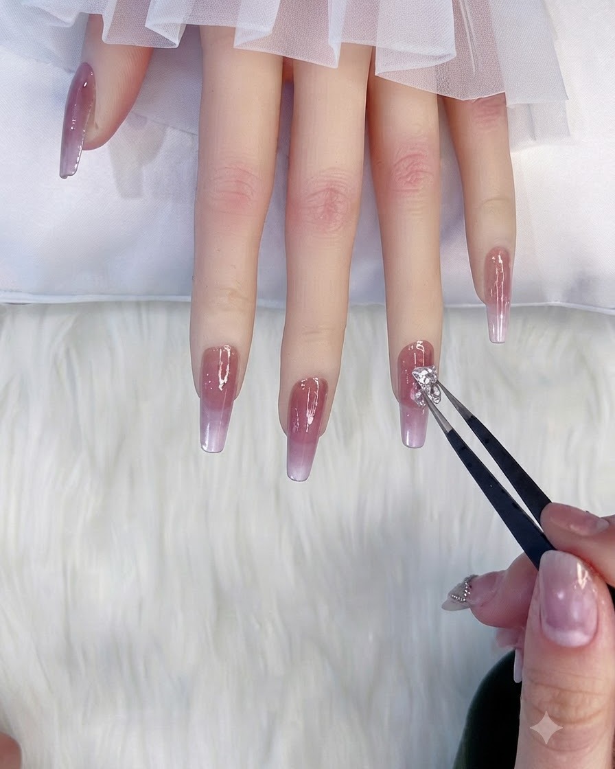 Tweezers placing a sparkling laser bear charm onto a decorated nail.