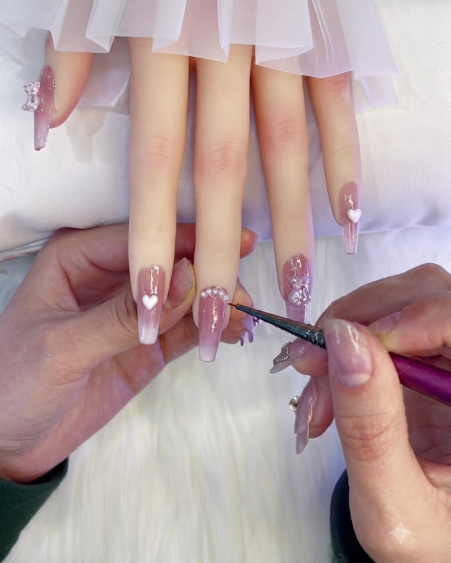 A fine liner brush carefully applying sealing glue around the base of the pearl decorations on the middle nail.
