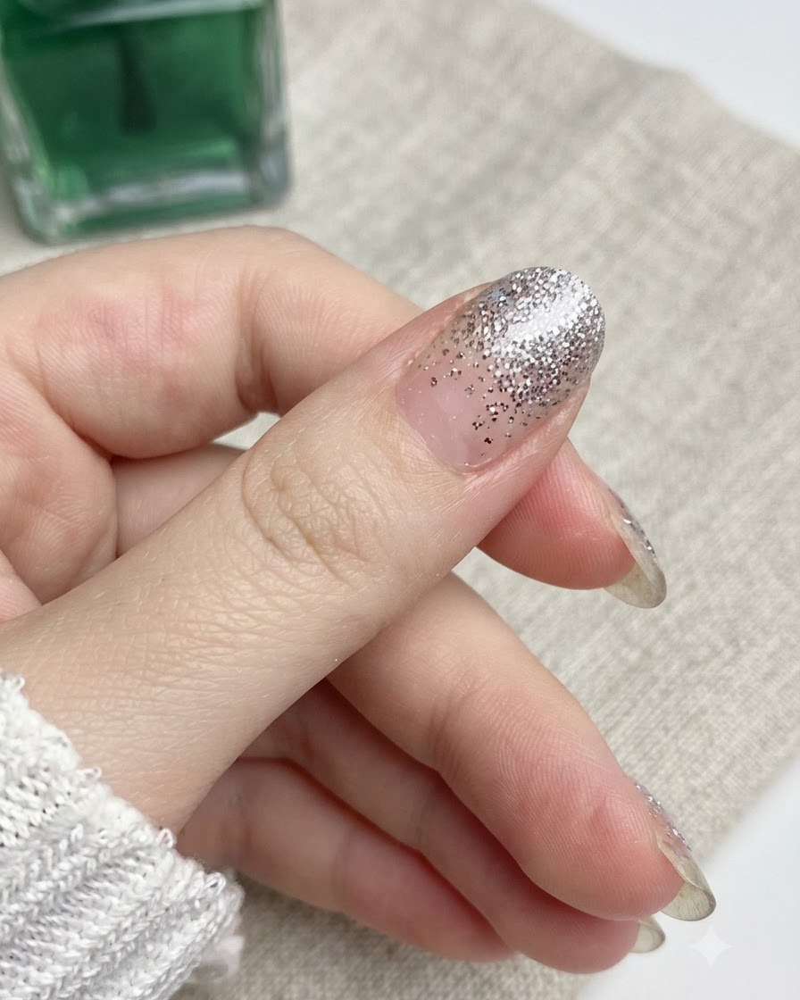 A nail file moving in a downward motion against the edge of a thumb nail.