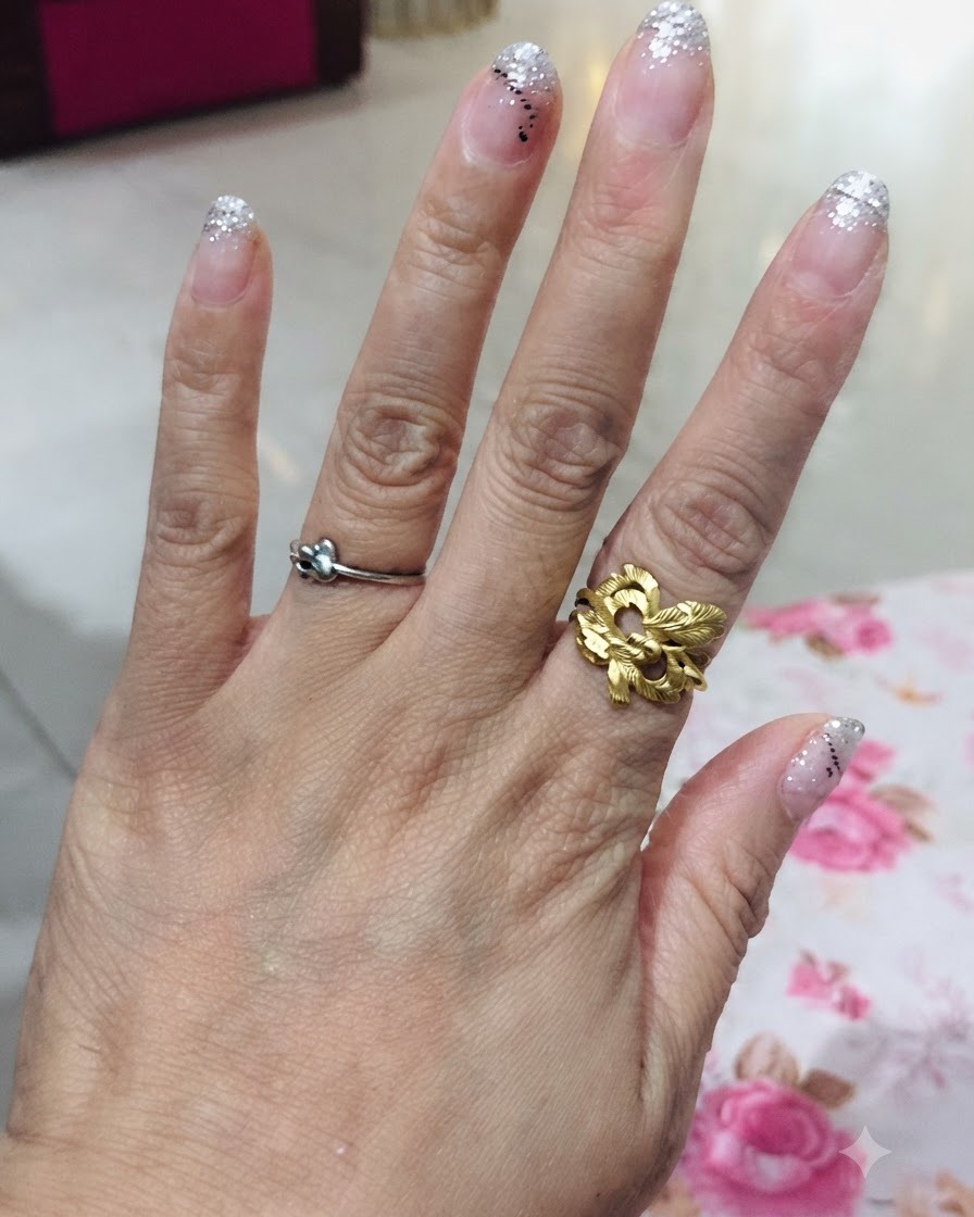 An overhead view of a hand displaying all five fingers with a silver glitter gradient design.