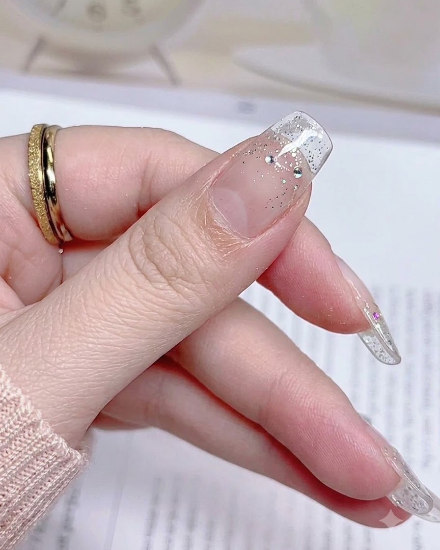 A close-up of a finished thumb nail after pulling away the excess sticker material, showing a neat edge.