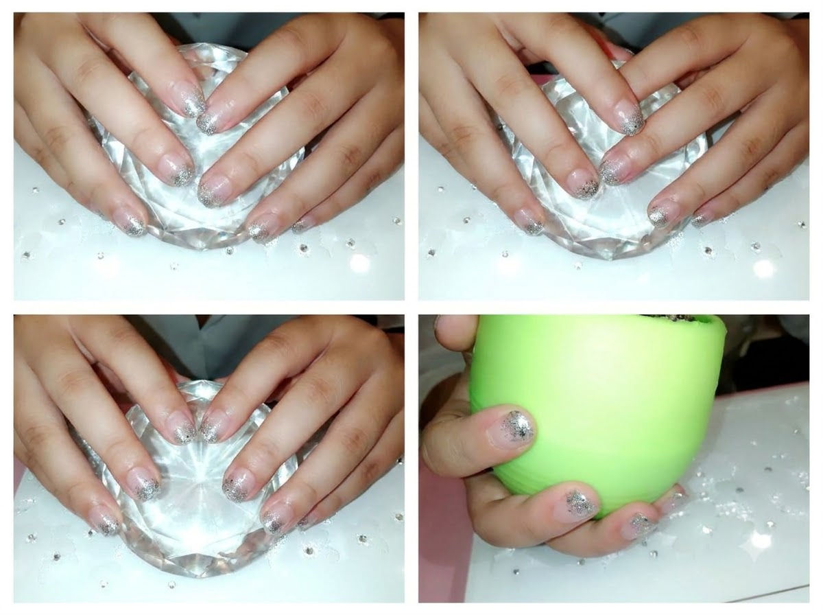 A pair of hands placed inside a green curing lamp with glowing light.