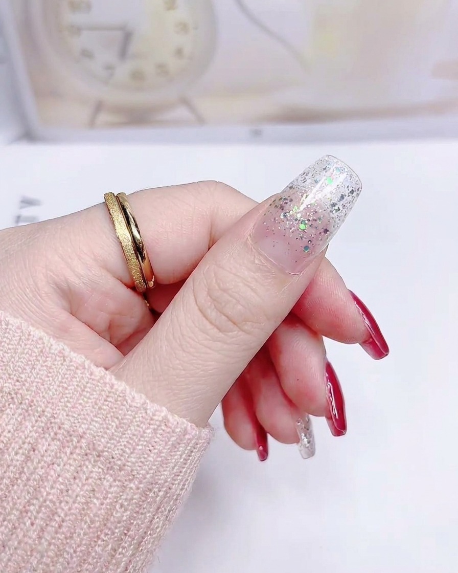 A thumbnail with a silver glitter gradient sticker applied smoothly from cuticle to tip.