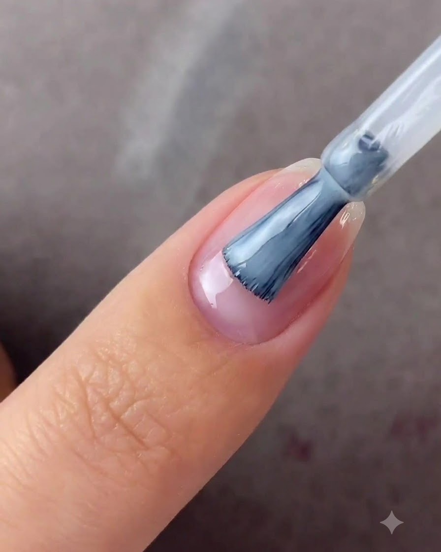 A fingernail positioned under a blue UV/LED curing lamp.