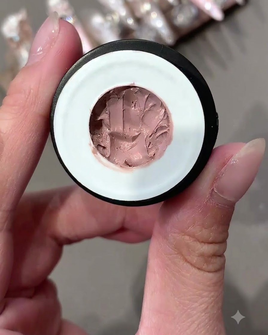An open container of pink-toned solid pudding gel shown up close.