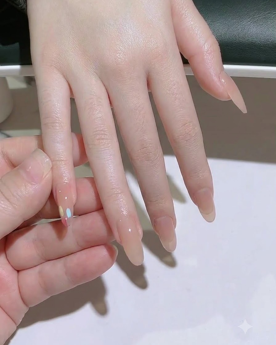 A lint-free wipe cleaning the nail plate of the middle finger.