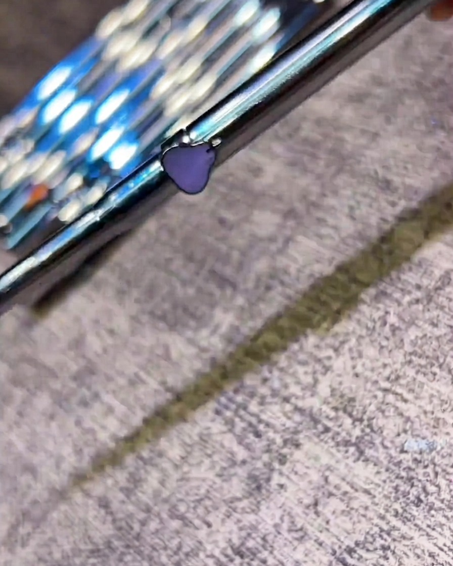 A nail art brush applying a glossy top coat over a finished nail design.