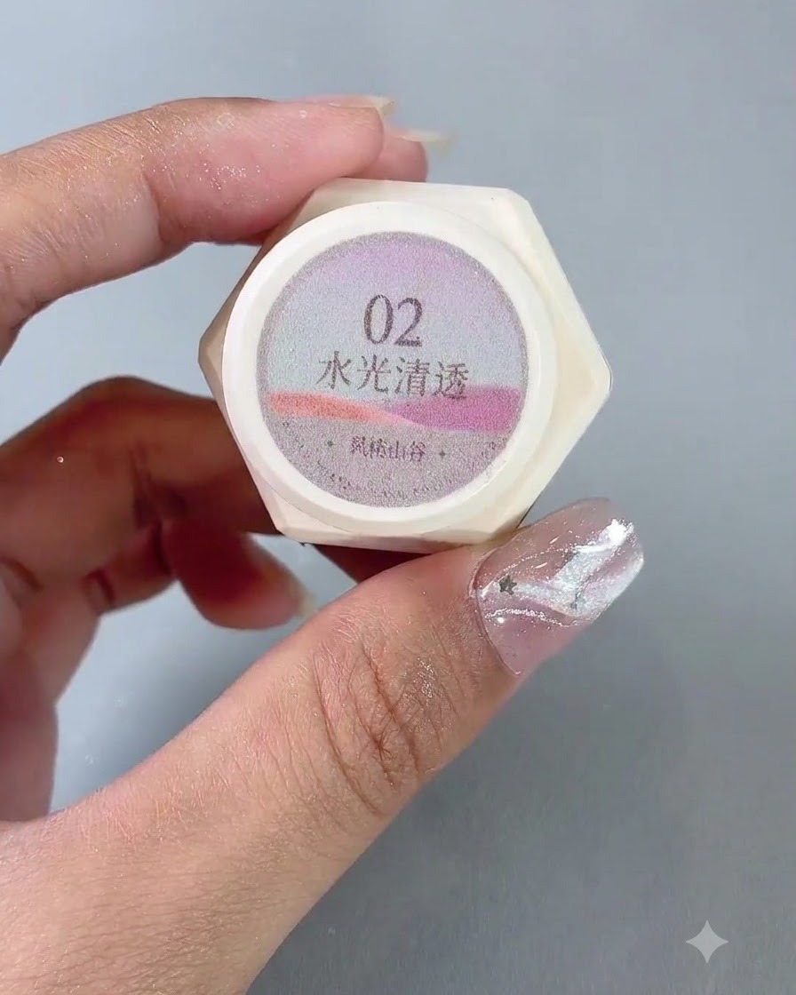 A pair of hands holding up a jar of number 2 water-gloss translucent cat eye gel polish.