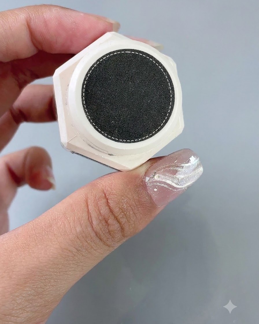 A container of texture styling gel held next to a nail with a French sticker guide applied.