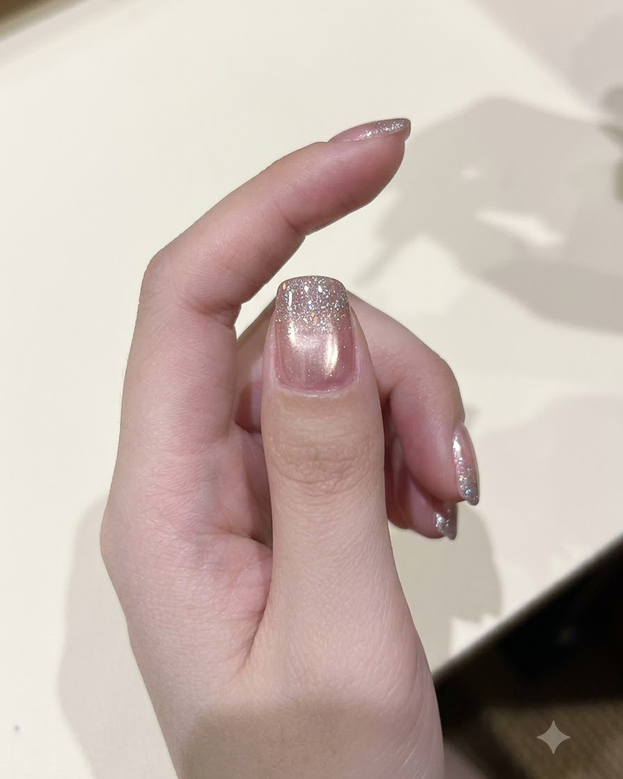 A polish brush applying a layer of sparkling diamond glitter gel over a cured nail.