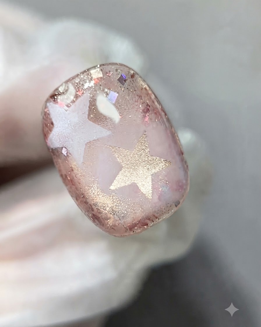 A coat of clear builder gel being applied to level the textured glitter surface.