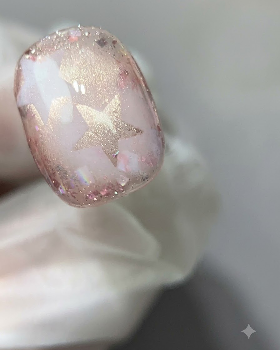 A close-up view of a cured pink cat-eye gel nail under a curing light.