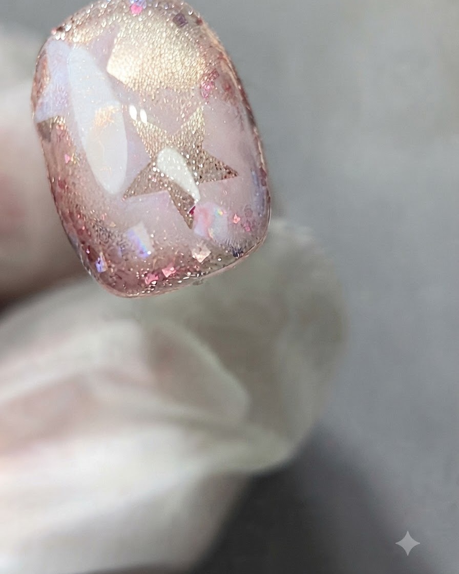 A sponge gently dabbing white gel onto a star sticker on a decorated nail.