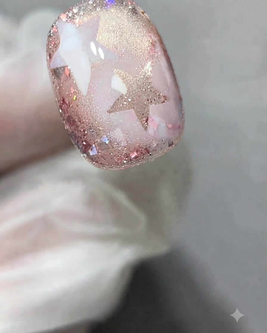 A star stencil sticker applied precisely onto the surface of a decorated gel nail.