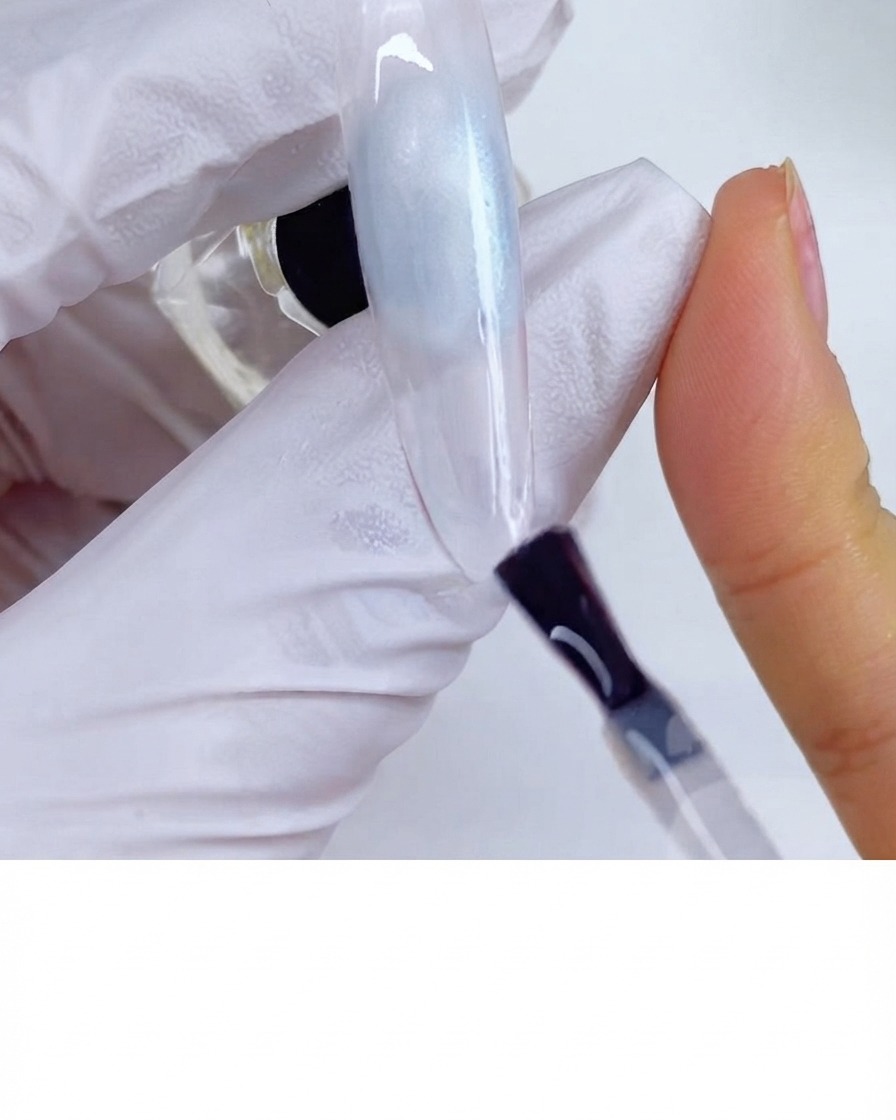 A brush applying matte top coat across the surface of a nail.