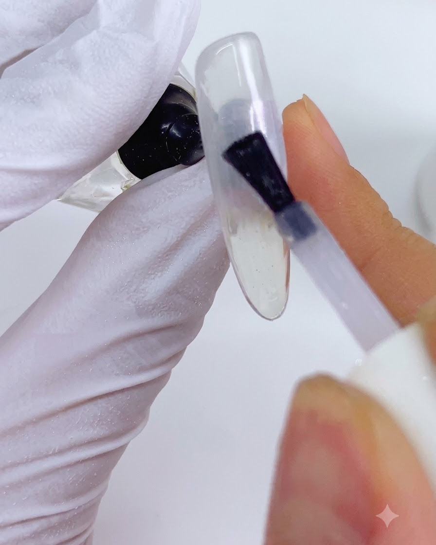 An applicator placing LP02 pearl powder onto the orange sections of the nail design.