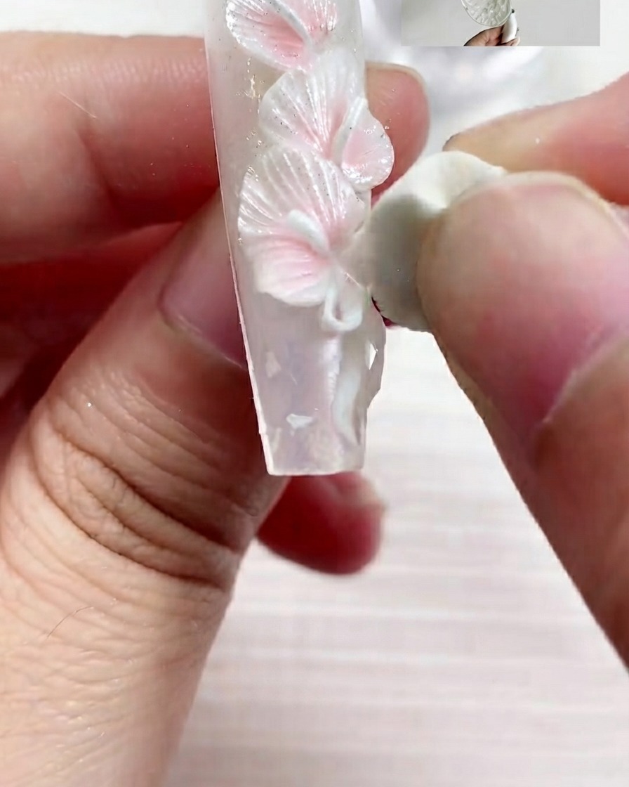 A flat brush applying S03 pearl texture gel onto the nail surface in smooth strokes.